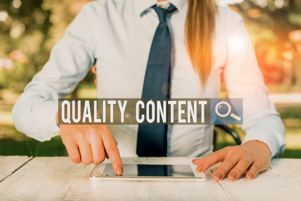 Writing note showing Quality Content. Business photo showcasing content that delivers value and consists of great writing Female business person sitting by table and holding mobile phone.