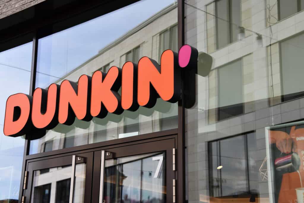 Dunkin' logo on window in city. 